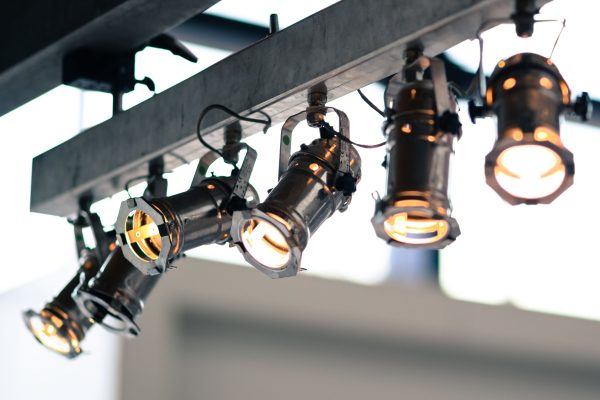 Modern industrial spotlights mounted on a ceiling providing focused illumination. Des projecteurs industriels modernes montés au plafond fournissant un éclairage focalisé.
