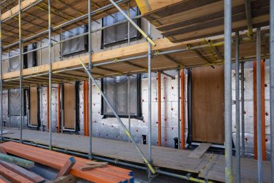 Chantier d'isolation avec panneaux visibles sur échafaudage
