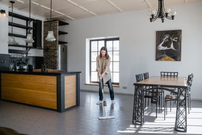 Femme qui lave un sol de cuisine avec une serpillière