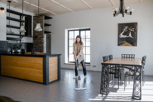Femme qui lave un sol de cuisine avec une serpillière