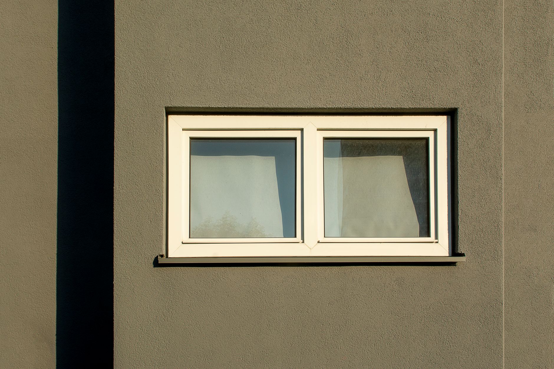 Fenêtre blanche en PVC sur façade claire