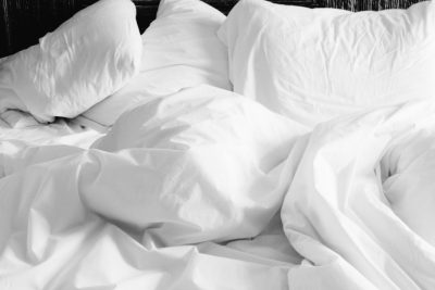 Couette blanche froissée sur un lit
