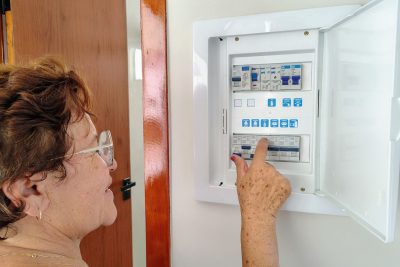 Femme qui réarme un tableau électrique