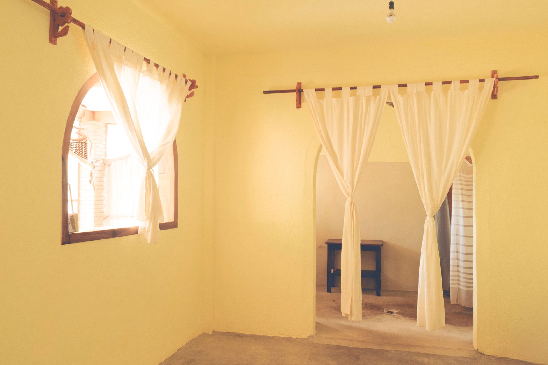 Arches et rideaux crème dans un salon