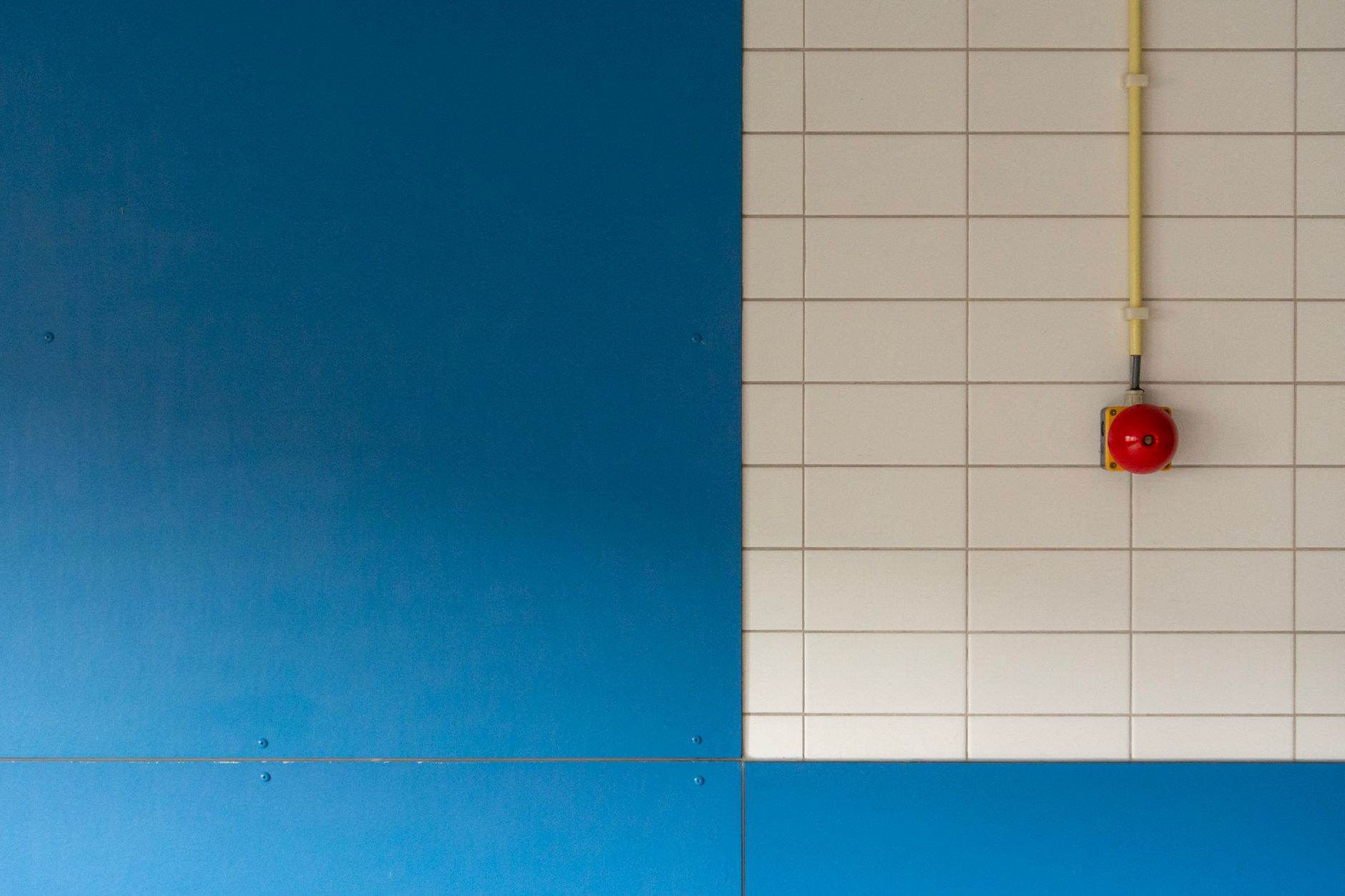 Bouton d’urgence rouge sur un mur bleu