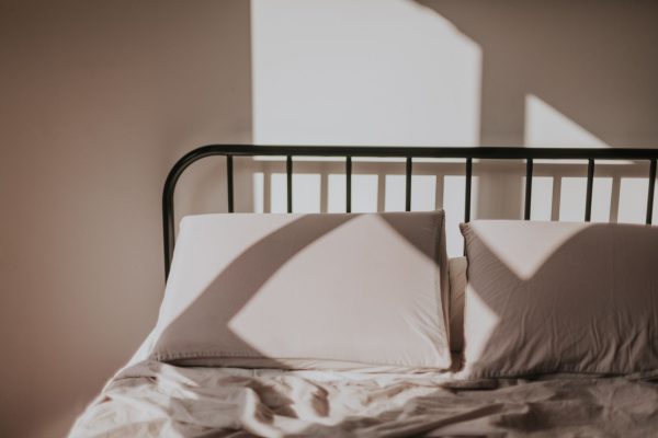 Lit blanc éclairé par le soleil dans une chambre