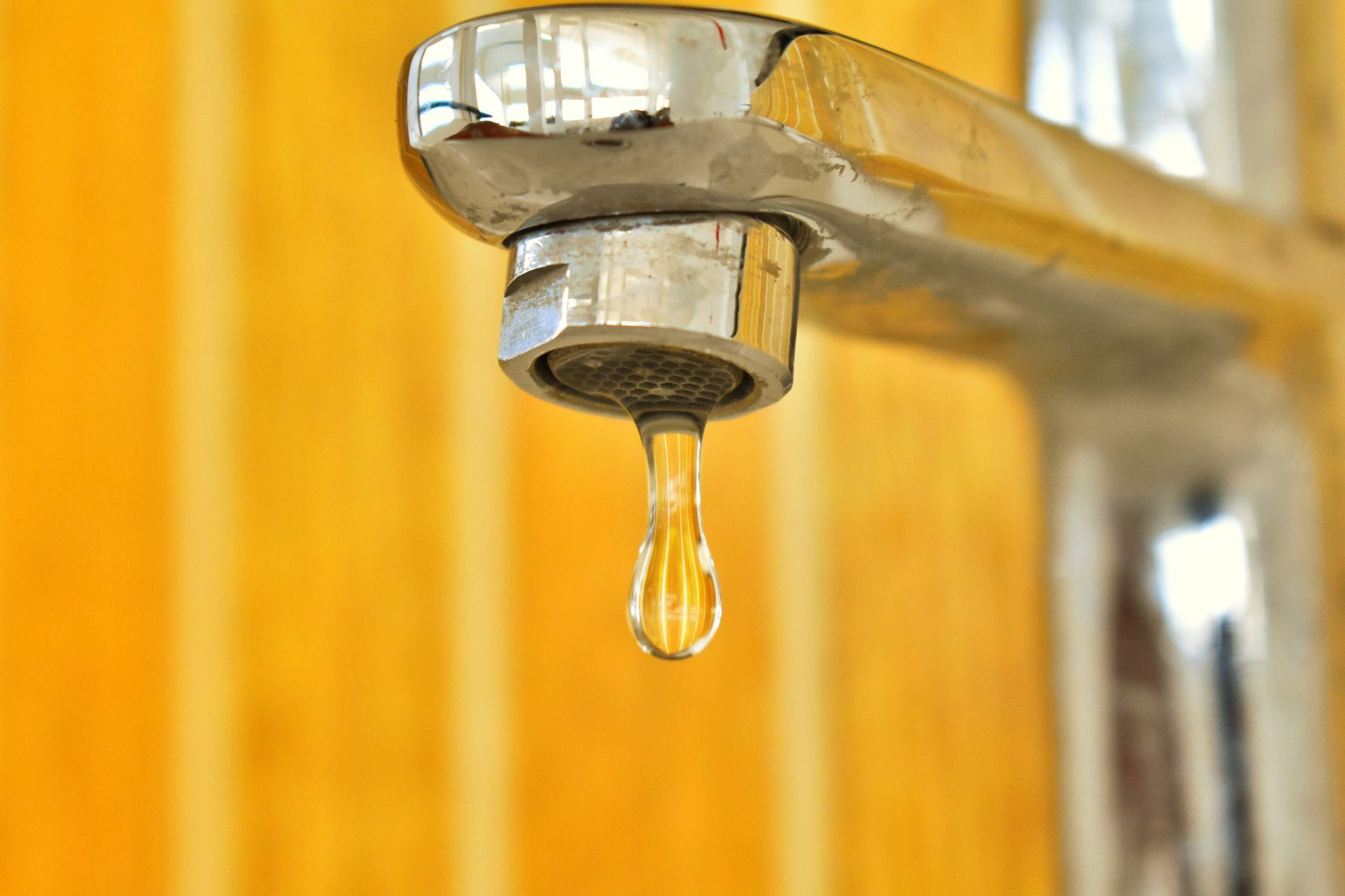 Goutte d’eau suspendue à un robinet
