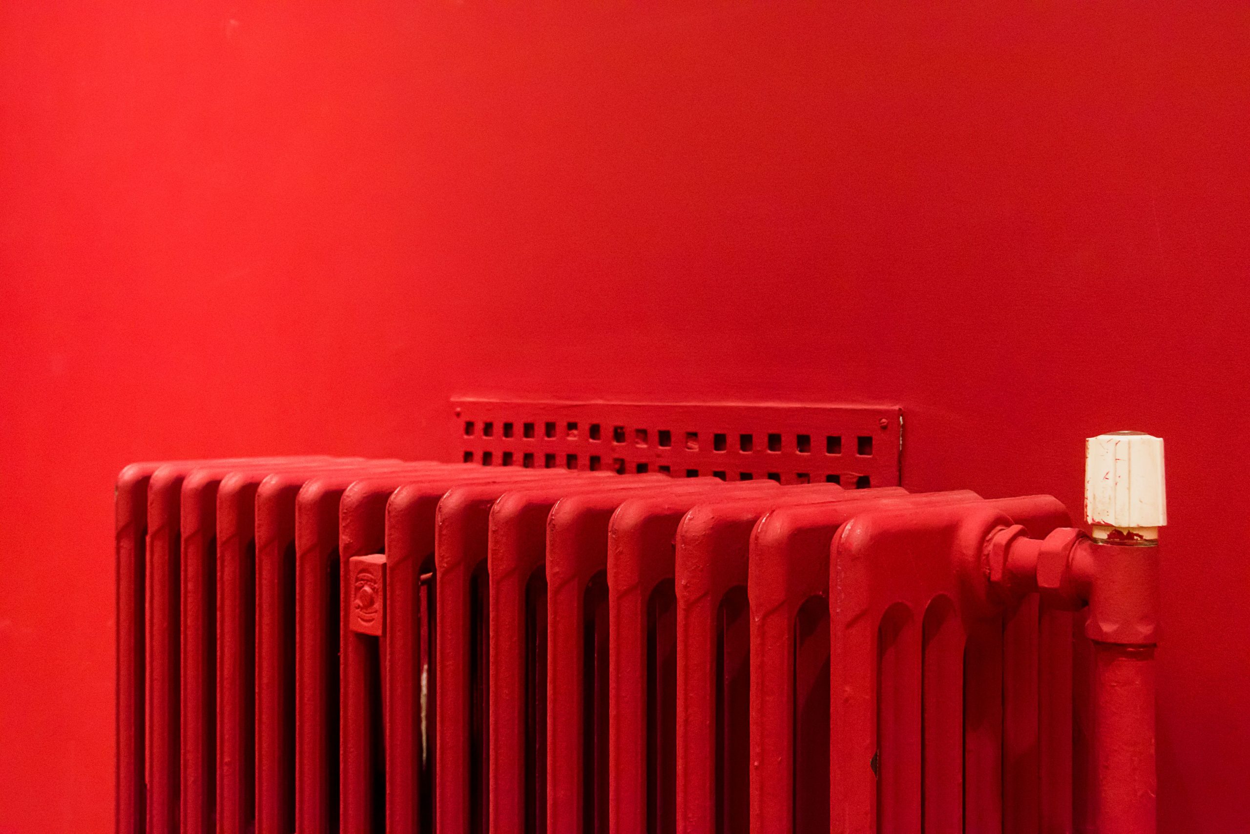 Radiateur rouge contre un mur assorti