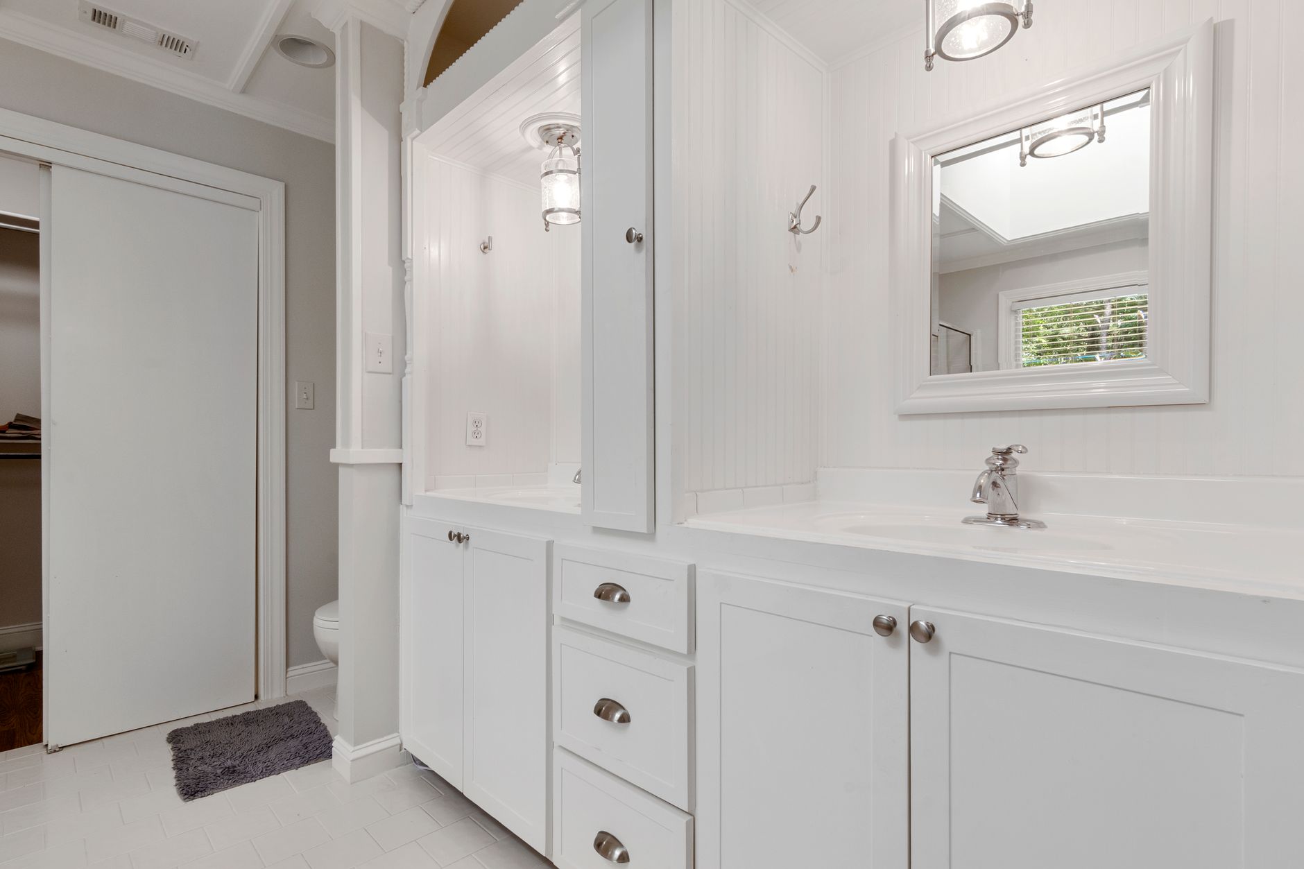 Salle de bain blanche avec meuble vasque et rangements