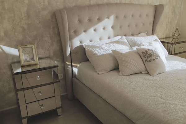 Chambre avec tête de lit rembourrée et oreillers
